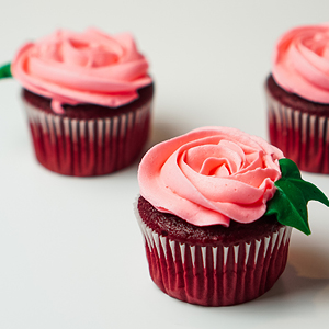 Cupcakes topped with pink rose-frosting flowers